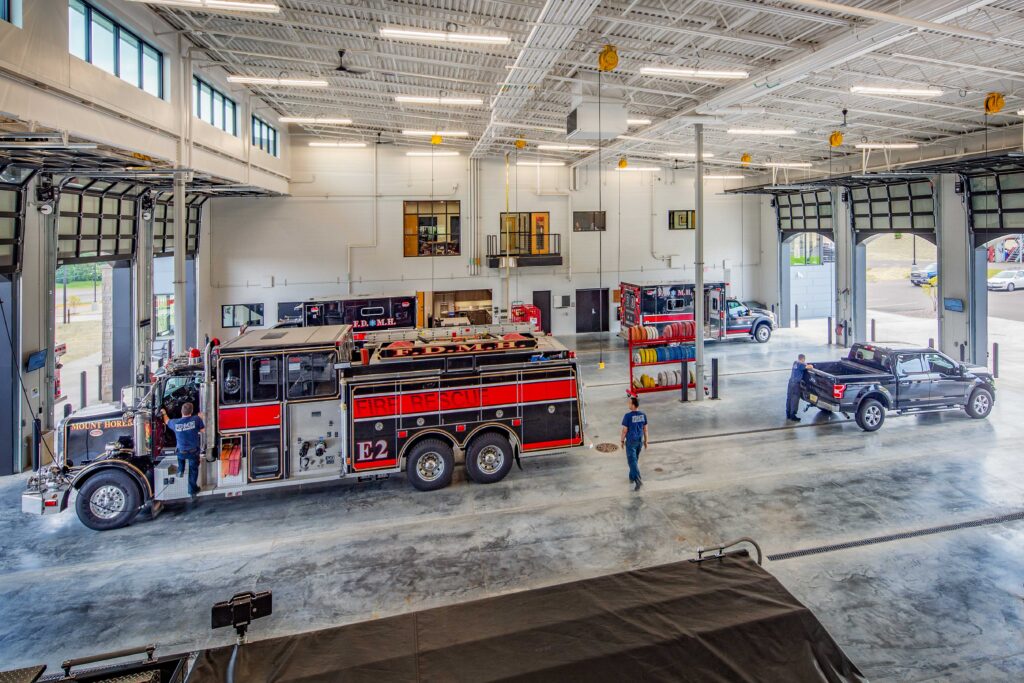 Interior view from above of fire trucks parked inside a bay