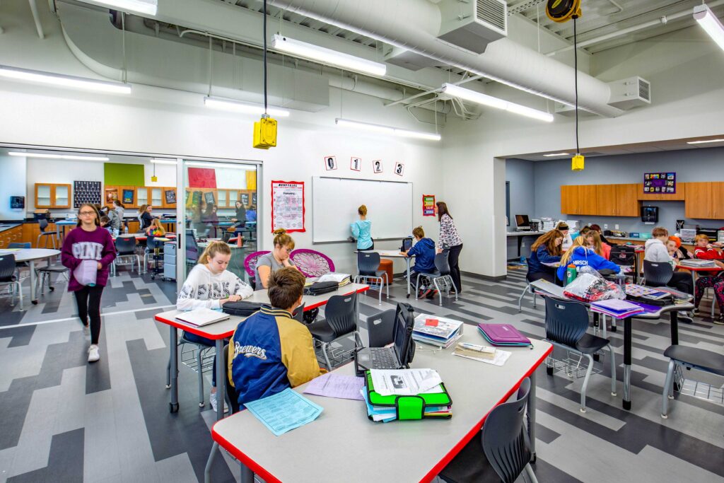 Students work together in one of the classrooms that is adjoined to another via sliding glass doors