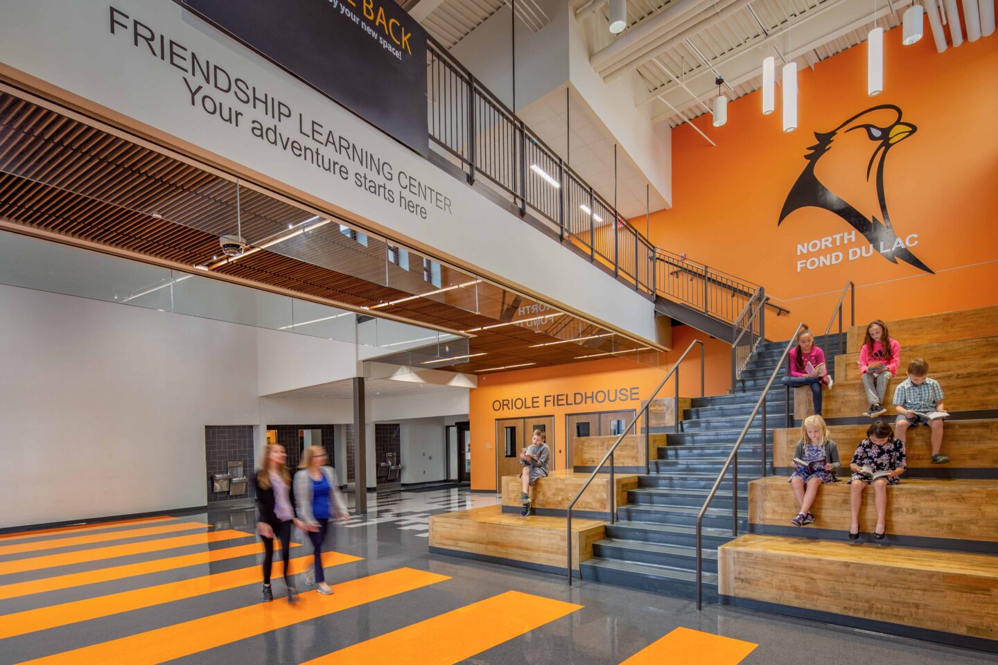 Students read on the learning stair near the entry to the fieldhouse