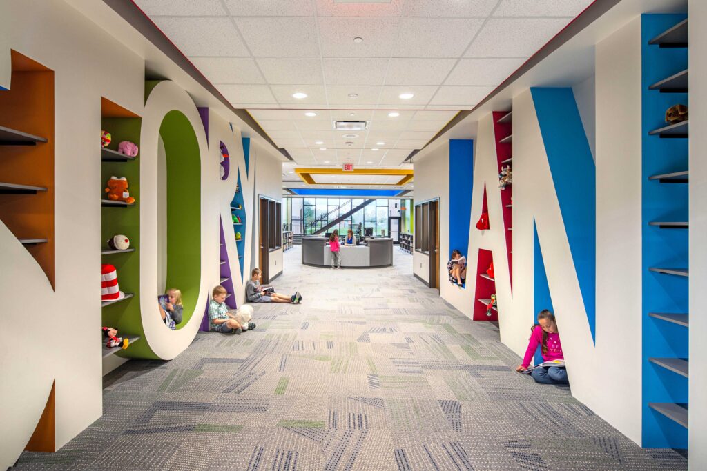 Students nestle into the reading nooks created by the large letters spelling "Storyland" in the entrance to the school's library