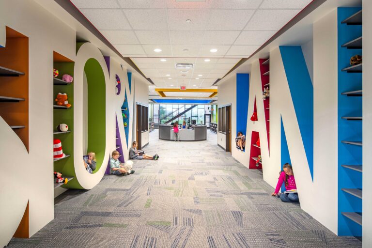 Students nestle into the reading nooks created by the large letters spelling "Storyland" in the entrance to the school's library