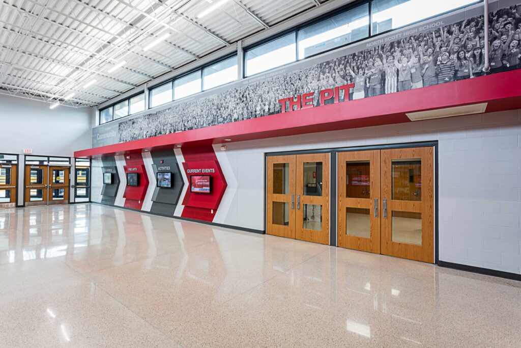 A view of one of the branding walls in the high school lobby, which also features clerestory windows for natural light