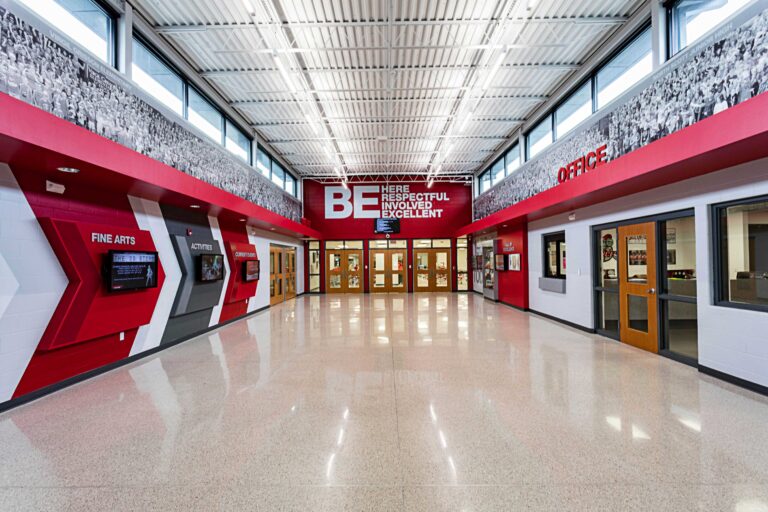 A view of the main entry lobby featuring large environmental branding installation on both sides of the corridor