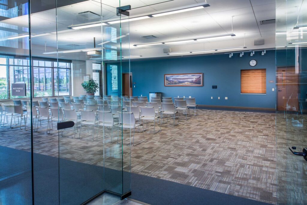 A windowed and open meeting space provides community access at the Oak Creek City Hall and Public Library