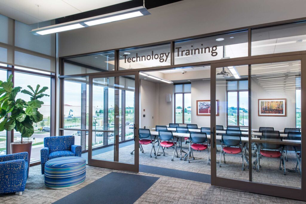 A bright, windowed meeting room labeled "tech training" provides community space at the Oak Creek City Hall and Public Library