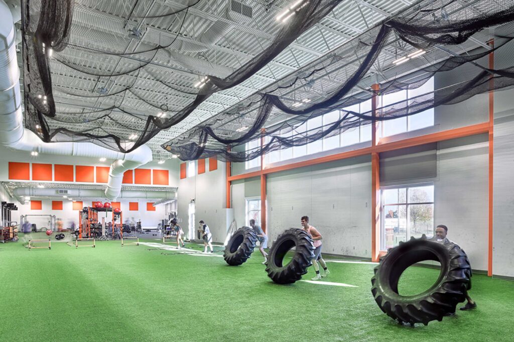 Students practice drills in the indoor turf area