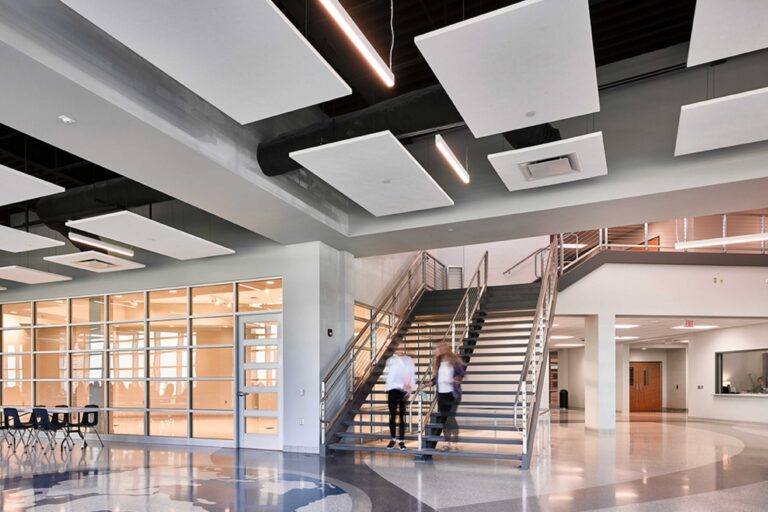 Students descend the staircase near the main entrance of the school