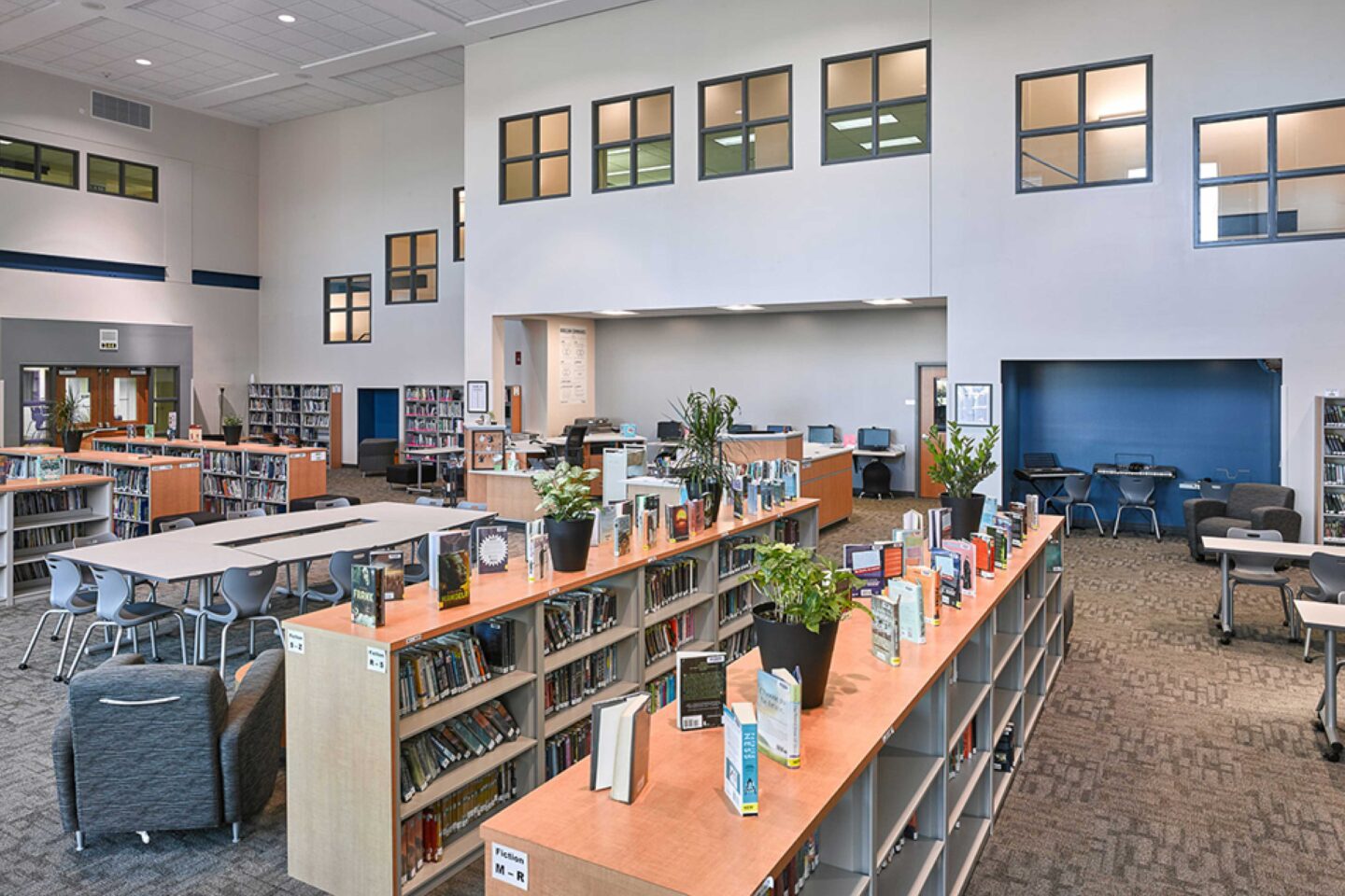 A view of the library, including reading nooks and windows that visually connect the library to the second floor learning areas