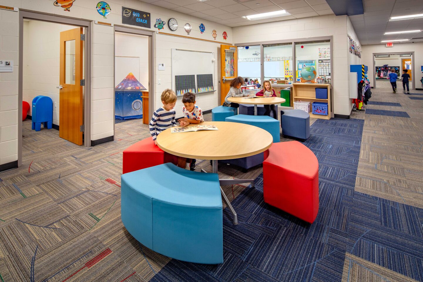 Elementary students work at a round table in an open nook connected to classrooms at Pewaukee Lake Elementary School