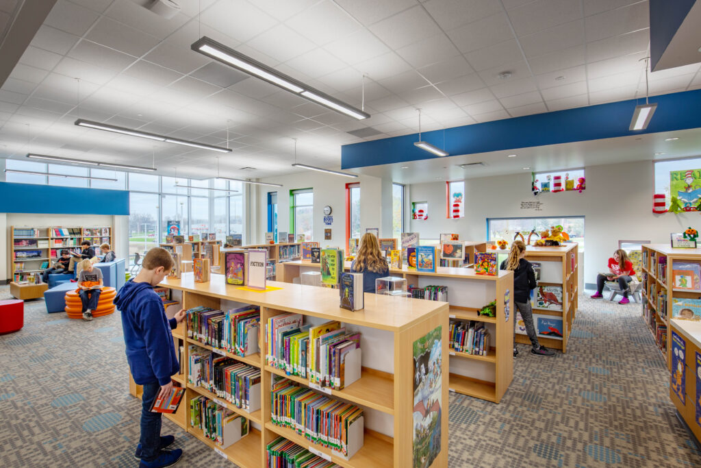 Students select books from shelves in the school library