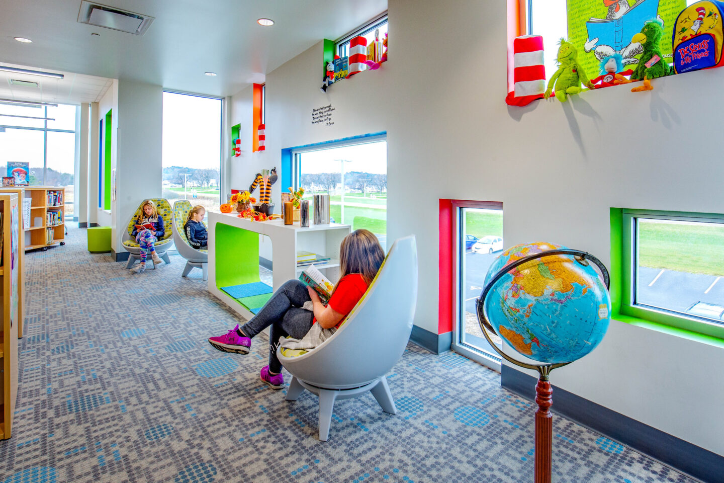 Student read in the comfortable library chairs near windows of various sizes and colors