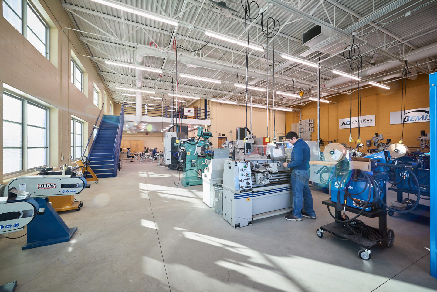 A large robotics workspace filled with equipment has a bright feel thanks to large windows at Sheboygan North High School