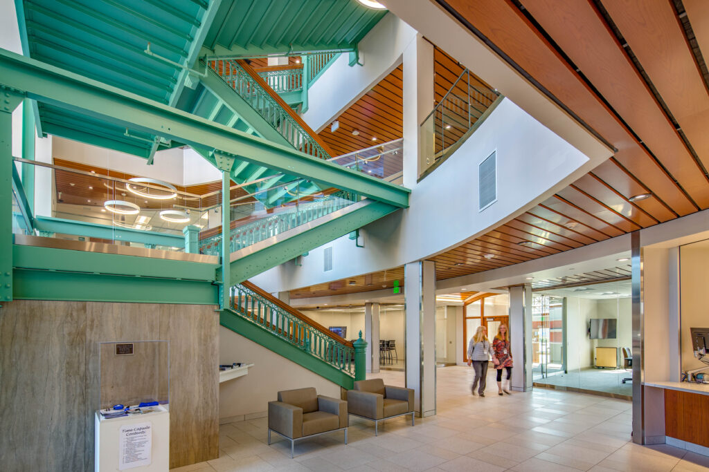 A modern entryway surrounds a historic, green painted staircase at Sheboygan City Hall