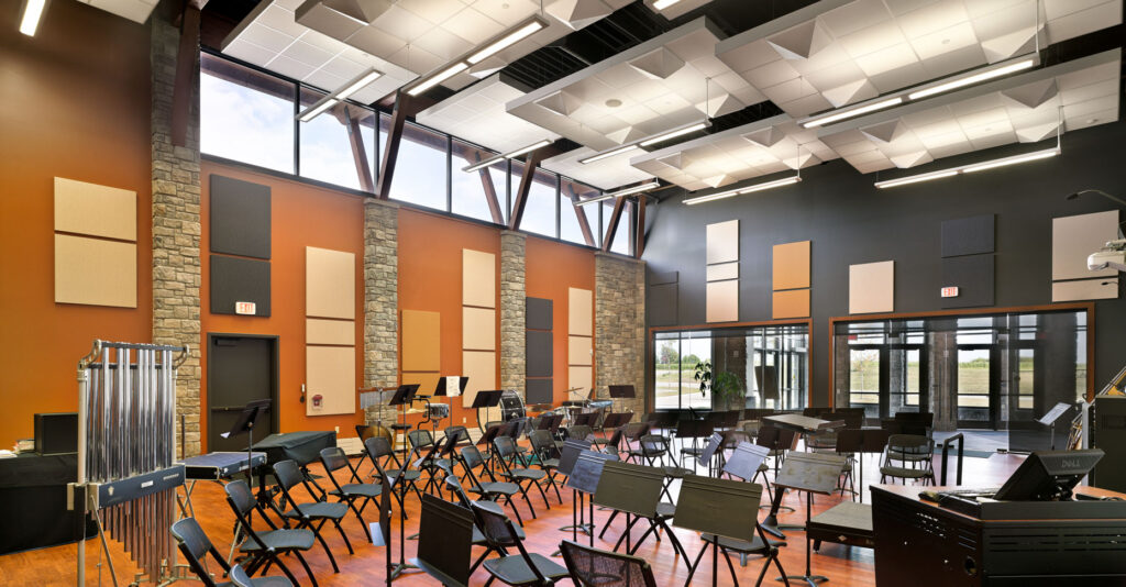 A high-ceilinged musical practice room that leads into a wall of windows