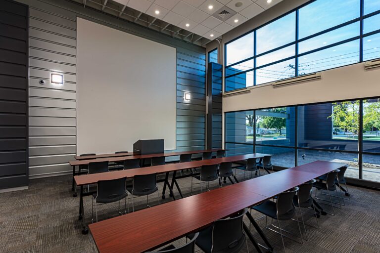 View toward the front of a large presentation wall backing up a windowed conference room
