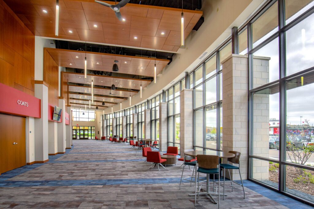 A view of the curved auditorium lobby with lounge-style seating and large floor-to-ceiling windows