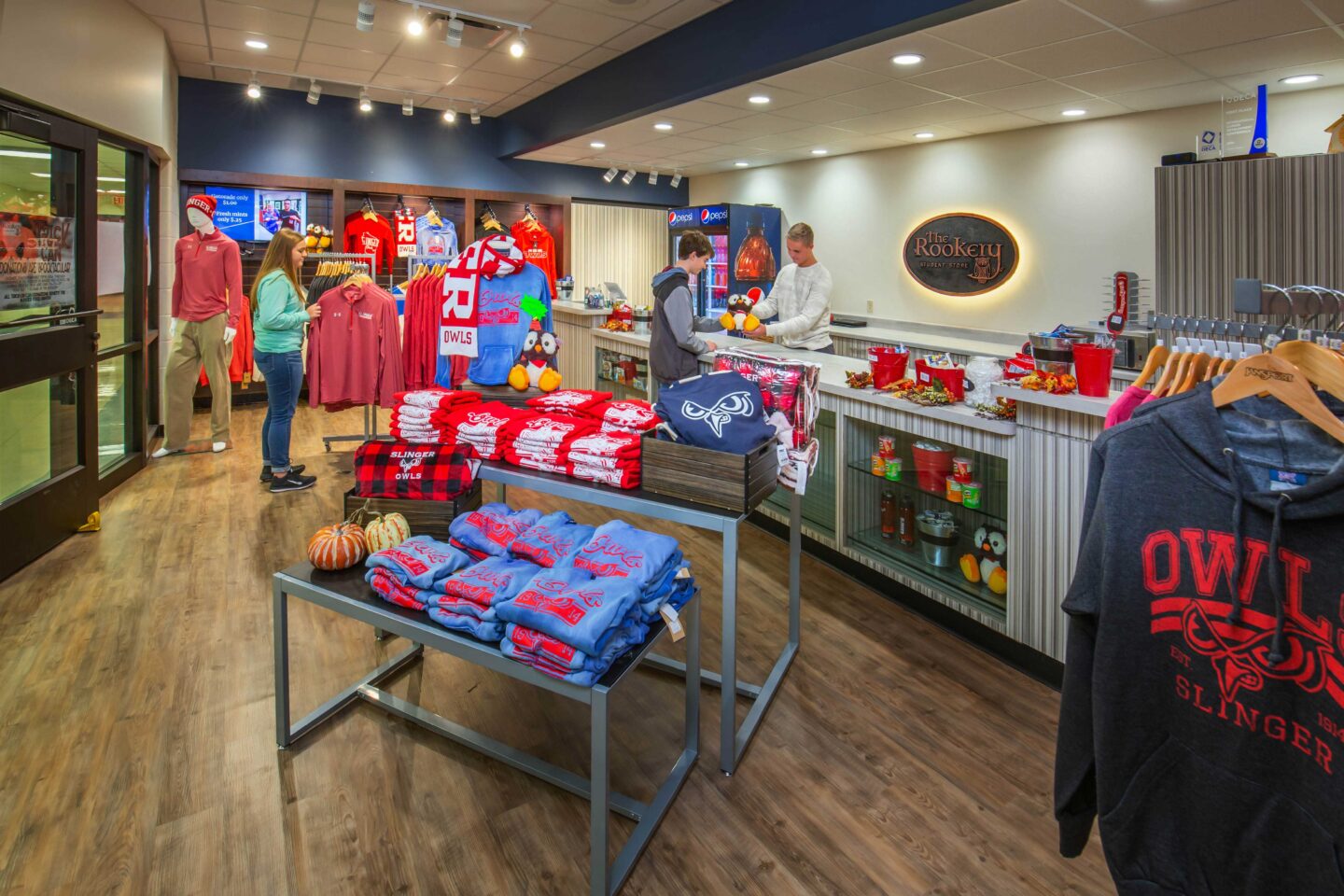 Two students complete a purchase in the school store, which is stocked with district-branded merchandise