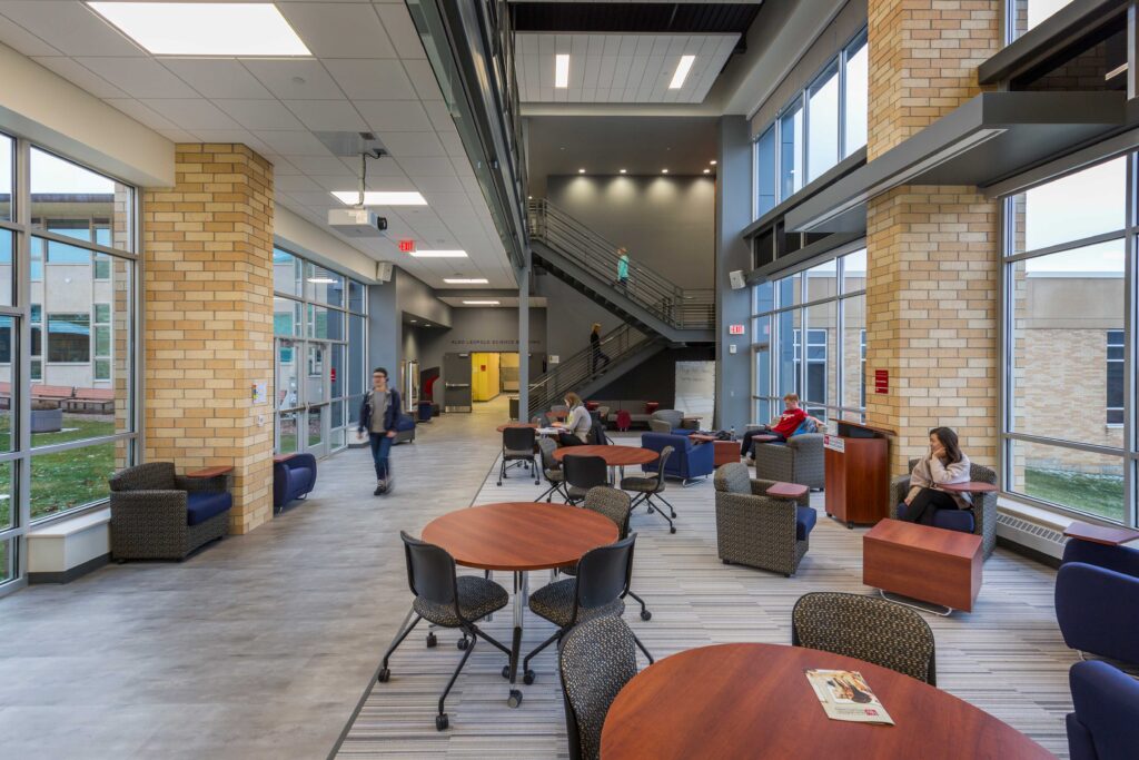 Round tables dot an open lounge space lined with large windows on both sides