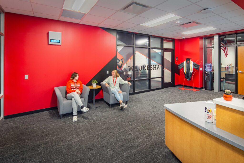 A colorful reception area welcomes visitors and shows school pride at Waukesha South High School