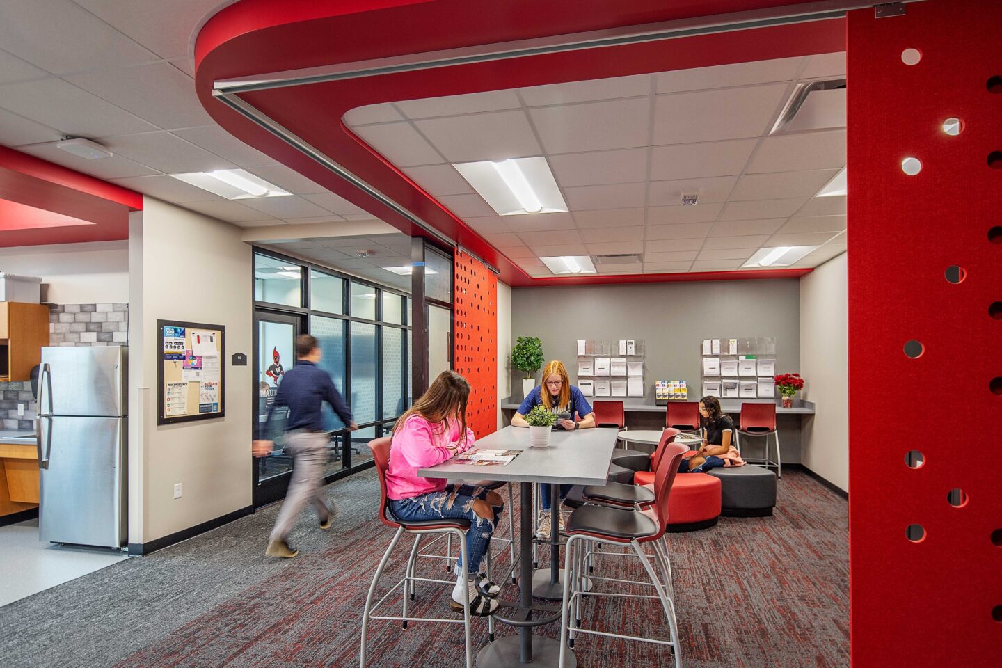 An open lounge area in student services features flexible furniture and school colors at Waukesha South High School