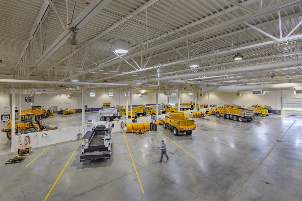 An overhead view of an open, well-lit garage area where county vehicles are stored