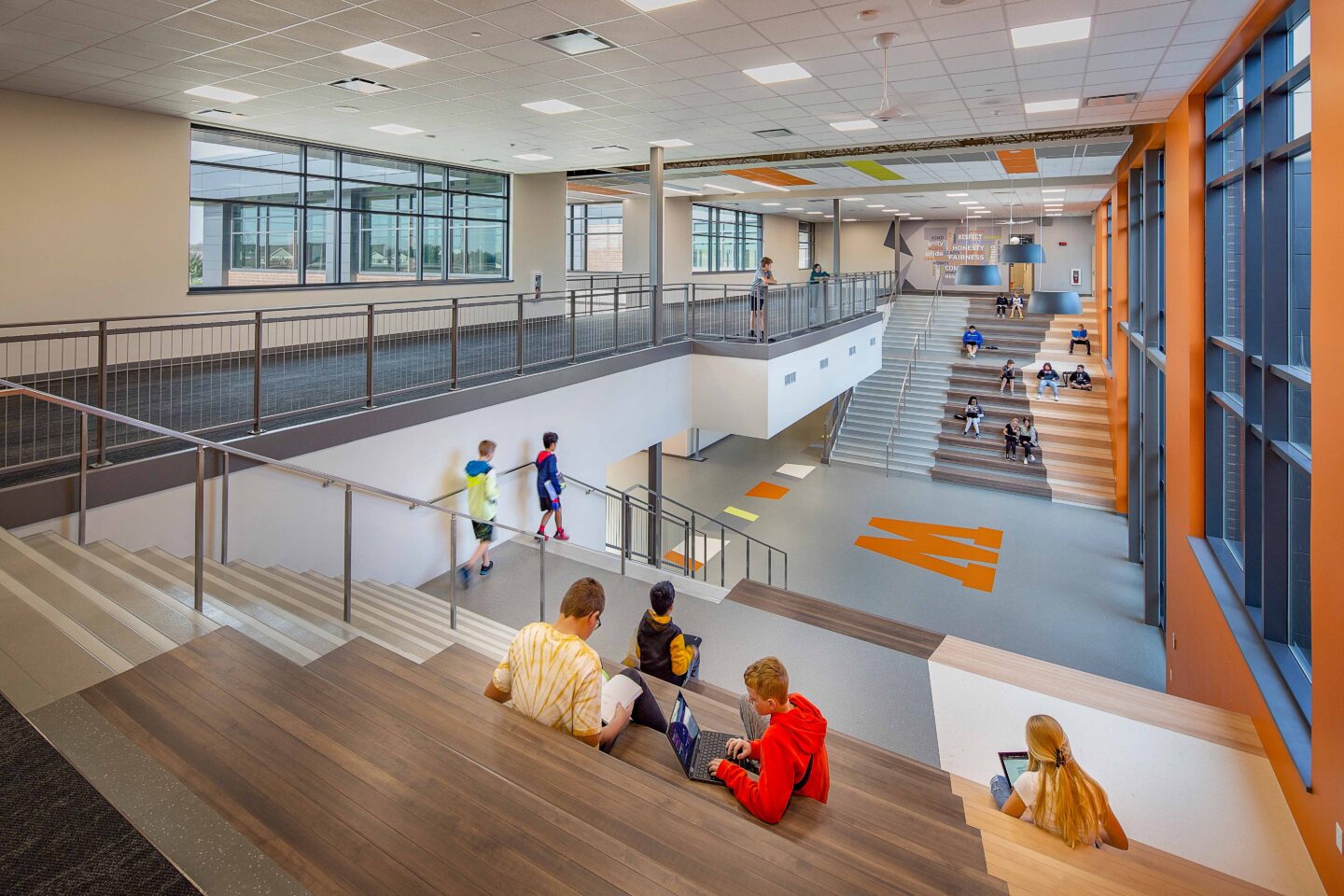 Students seating on both sides of the dual learning stairs with a mezzanine visible in the background