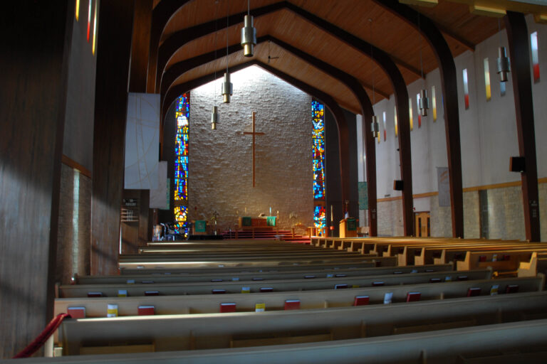 View of Zion Lutheran Church sanctuary features high wood ceilings and stained glass panels