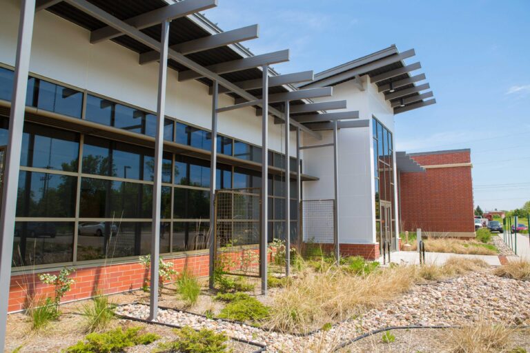 Landscaping leads to a windowed entrance area of the Madison Metropolitan Sewerage District building