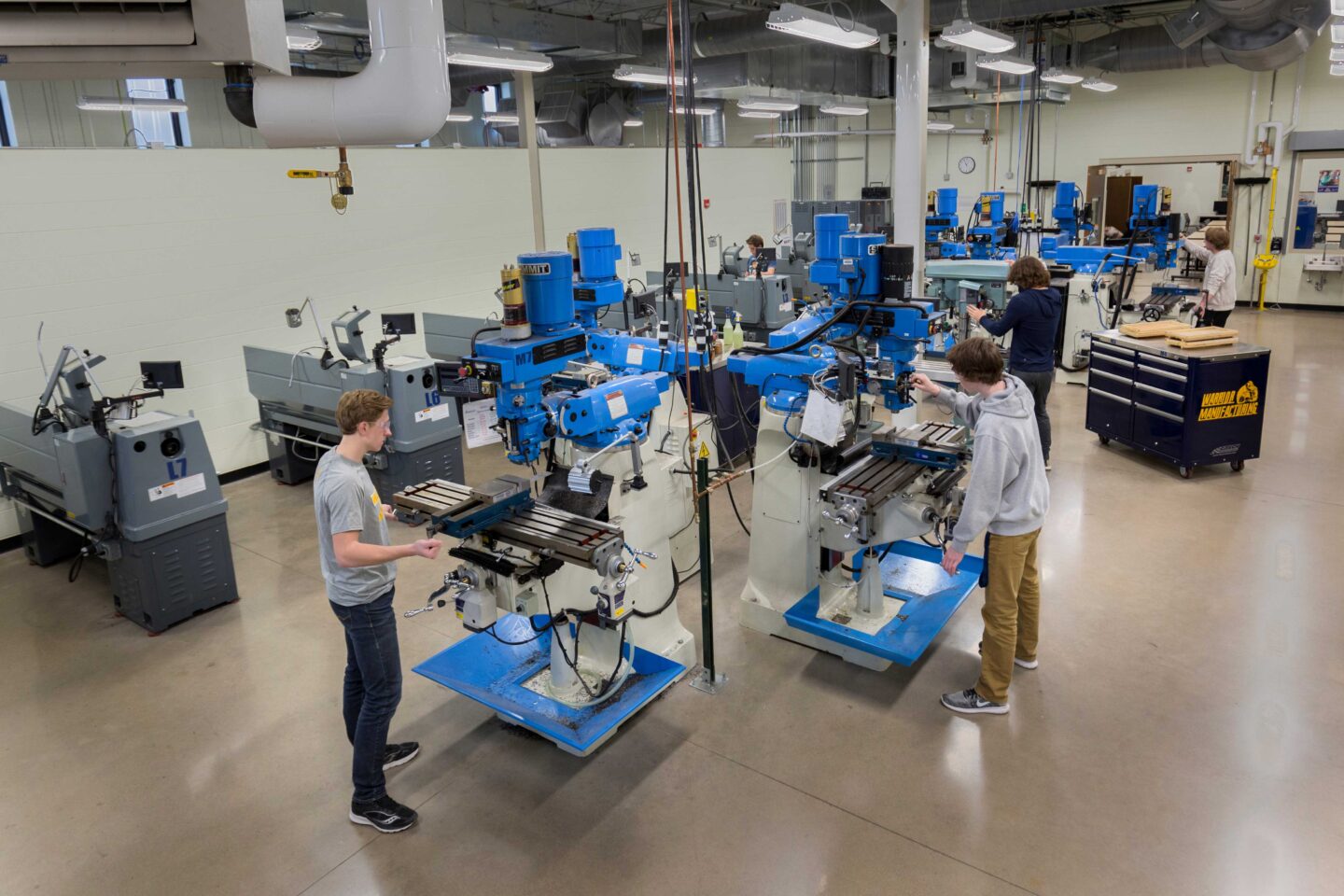 Students working at specialized equipment fill a large metal shop space at Wausau West High School