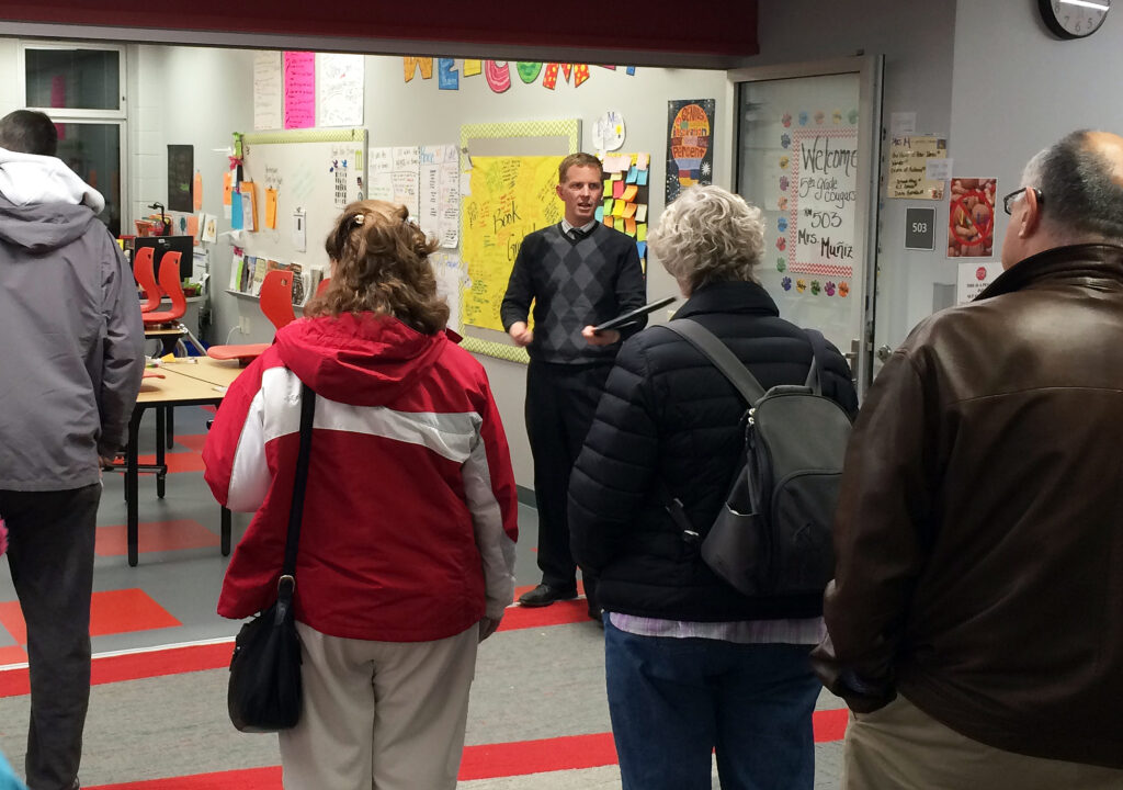 A Bray team member answers questions from members of the public as he leads tours into a classroom