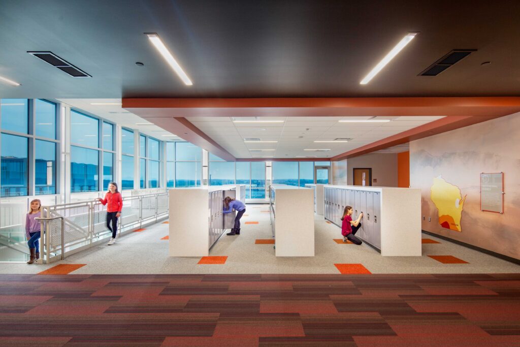 Lockers and activity space featuring Wisconsin graphic on wall and staircase