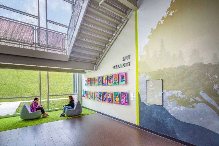 Staircase and seating area with branding on wall - art gallery from students