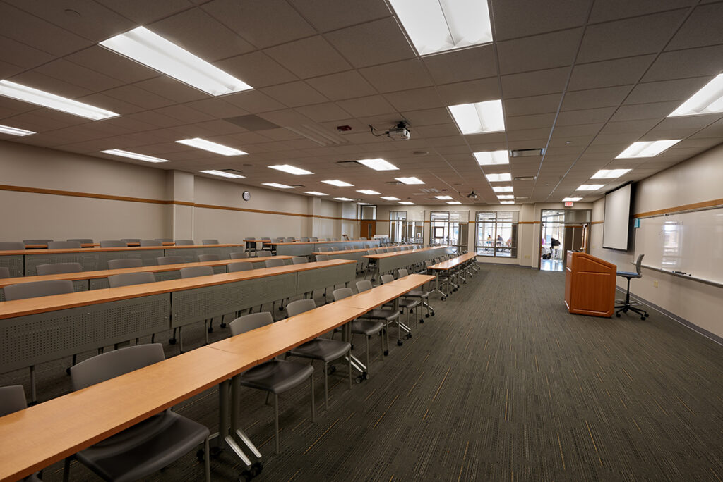 An overall view of a renovated lecture room featuring several rows of tiered desks and seating
