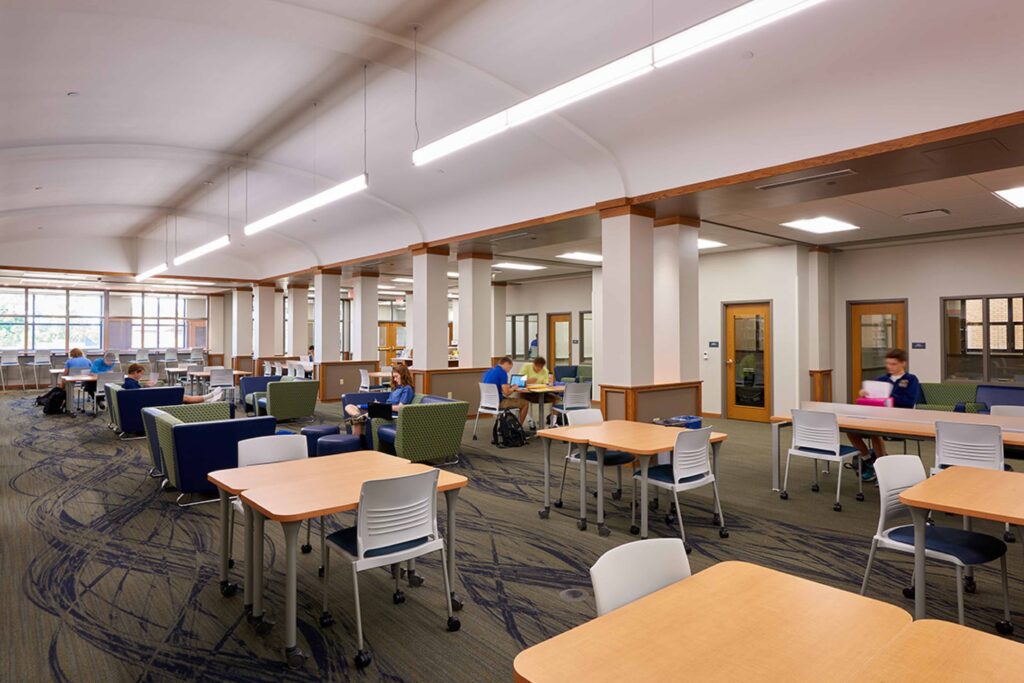 Students work under a barrel-vaulted ceiling in the school library