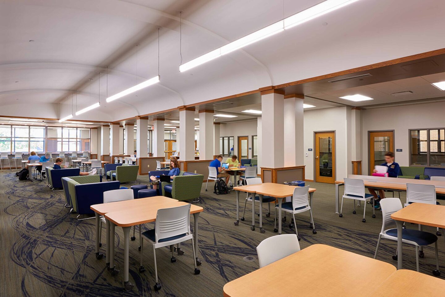 Students work under a barrel-vaulted ceiling in the school library