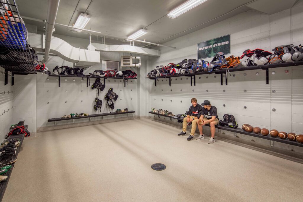 Football pads and equipment line the shelves of the school's mud room