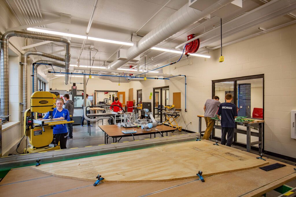 A view of the fabrication lab, which features power tools, robotic arms, and a CNC router.