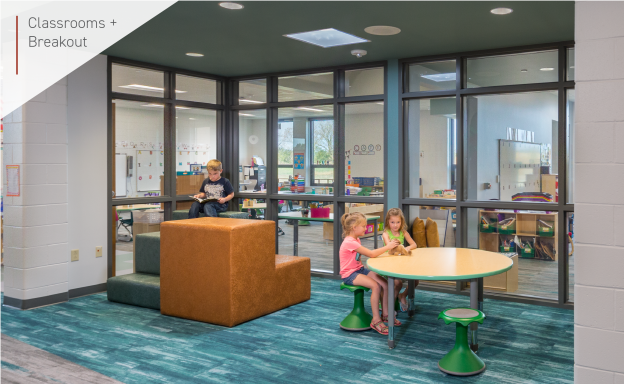 A view from the hallway of the breakout space with large windows into two adjacent classrooms