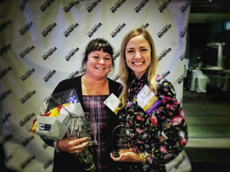 Ellen Del Vecchio and Stephanie Vierling smile as they hold their awards for Newsmakers of the Year 2021