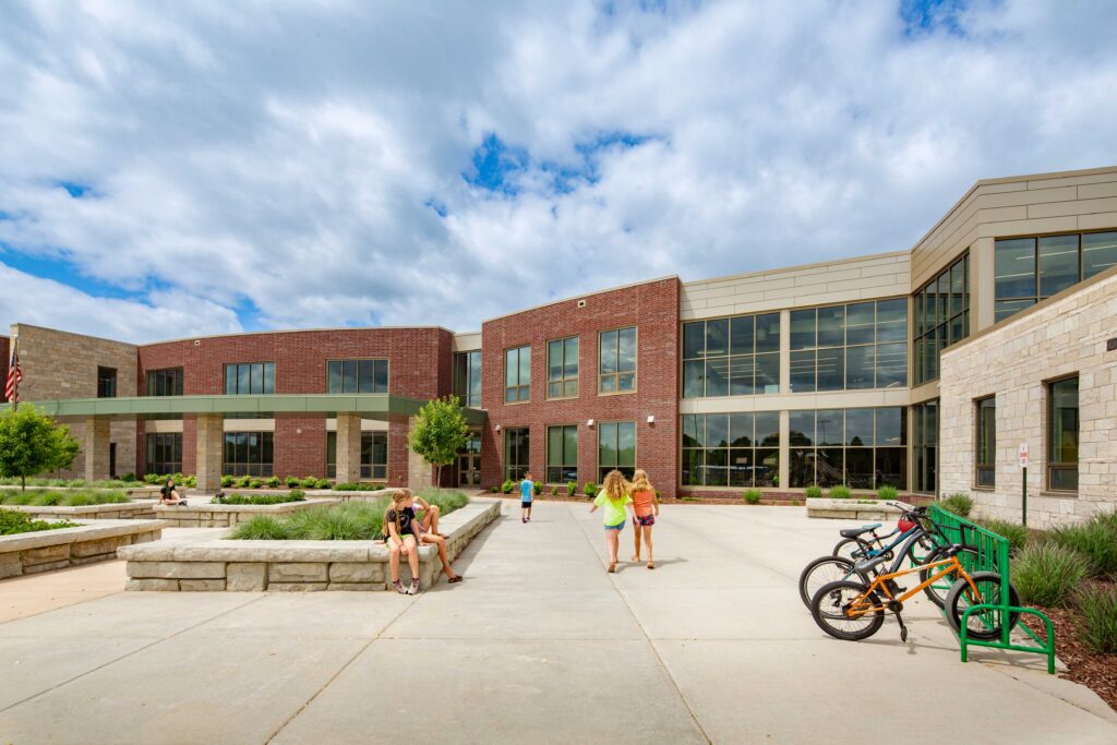 Baird Elementary School exterior of cafeteria with students walking and sitting