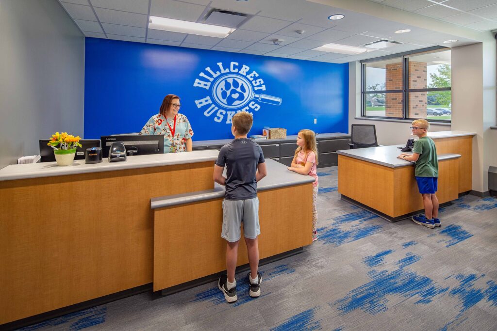 Students interact with a staff member in the office of Hillcrest Elementary School