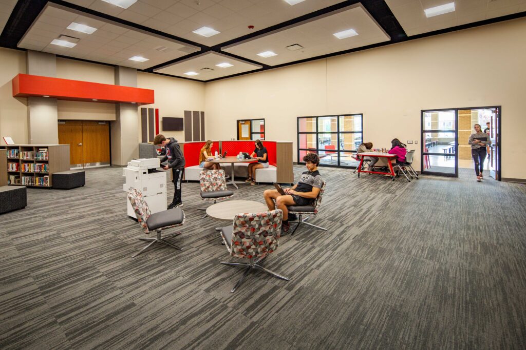 Oostburg High School library media center with students sitting and standing