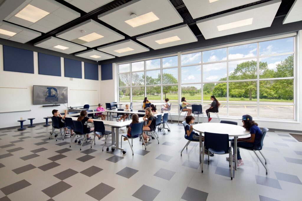 Danz Elementary School community room with students sitting and talking