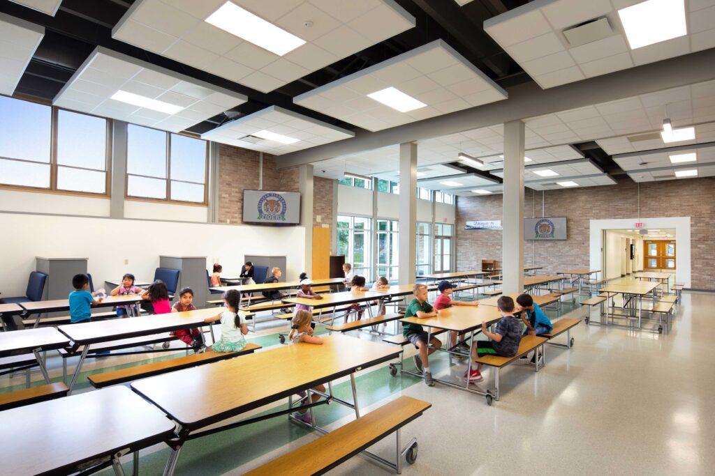 Sullivan Elementary School cafeteria with hallway in far end of photos and doors to exterior shown