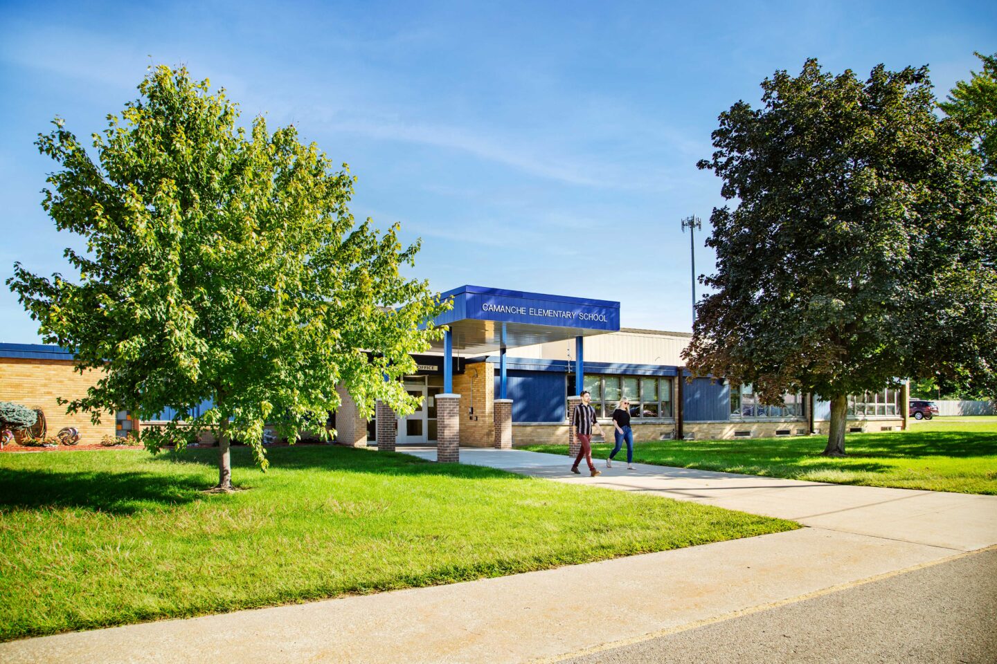 Camanche Elementary Front Entrance from an angle with two people walking out of the school