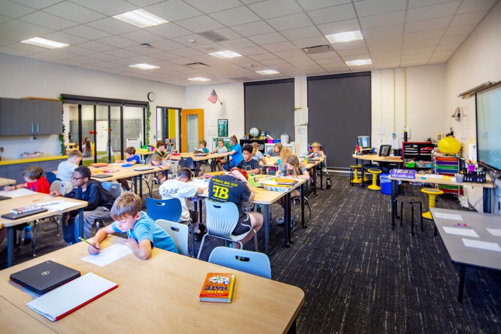 Herbert Hoover Elementary Classroom with students learning and glass sliding doors looking into collaboration area