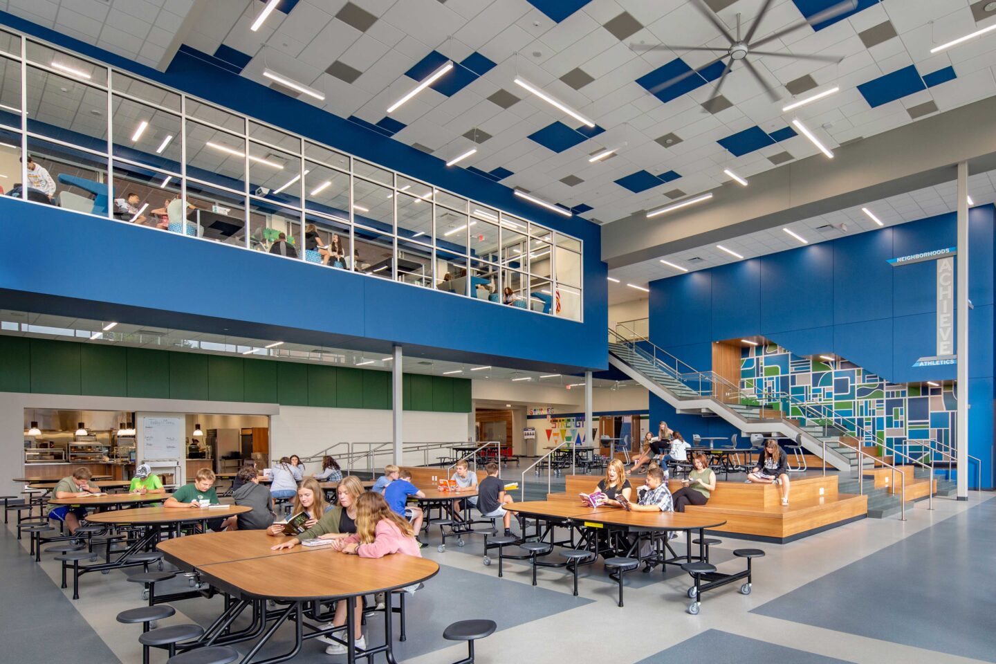 JC McKenna Middle School Cafeteria-Commons Area with glass windows looking up at the library where students are sitting