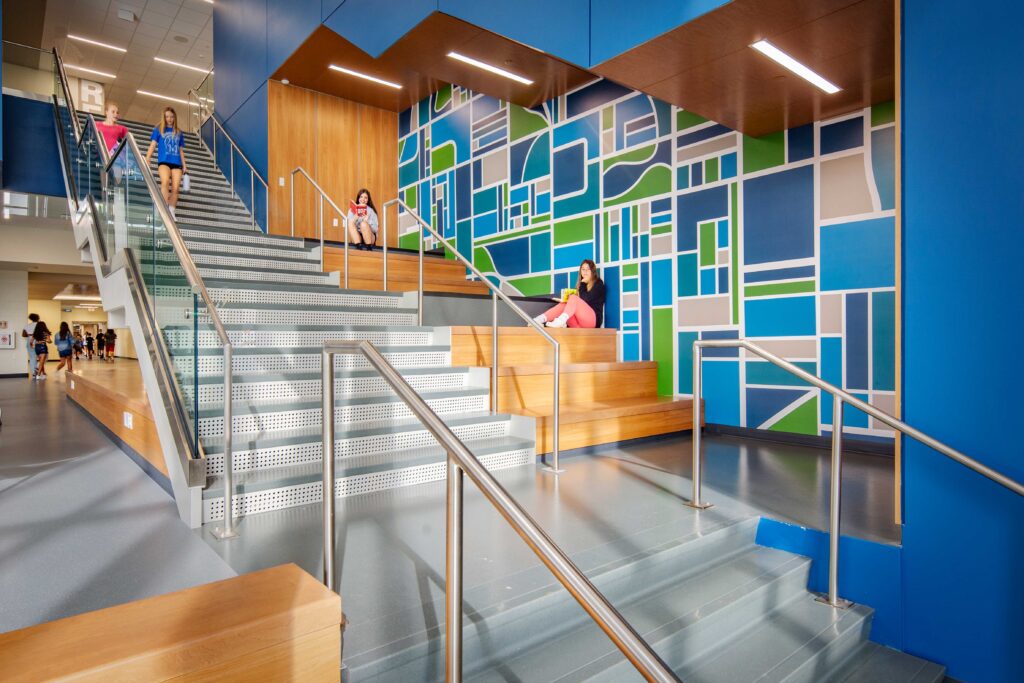 JC McKenna Middle School Learning Stairs with students sitting on the stairs reading and others walking down the stairs