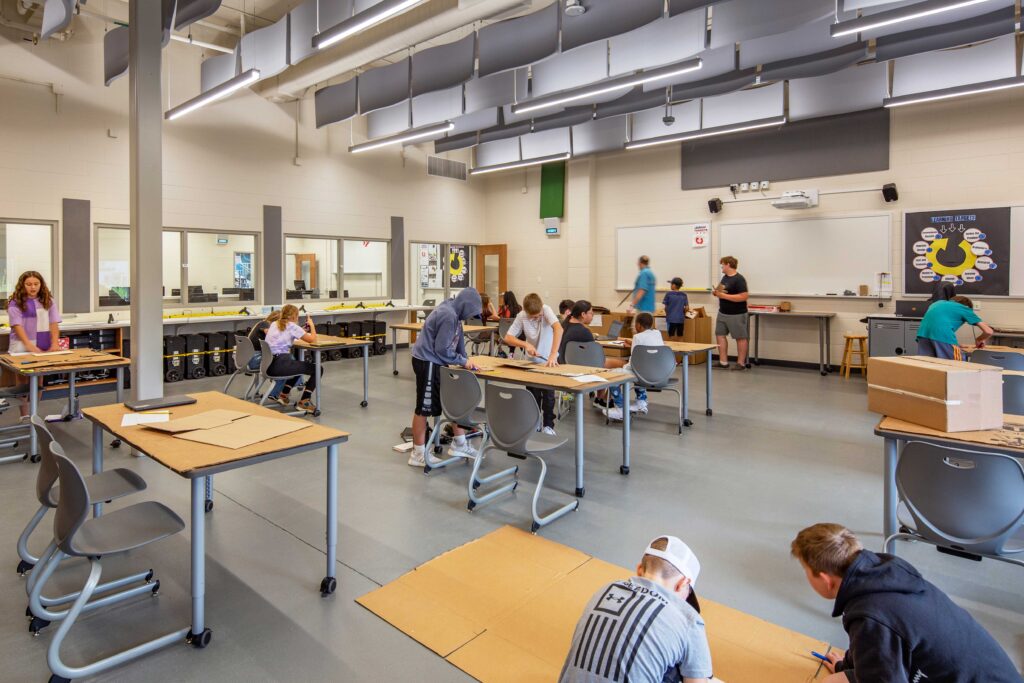 JC McKenna Middle School STEAM Room with windows into the computer lab room and students working on a project