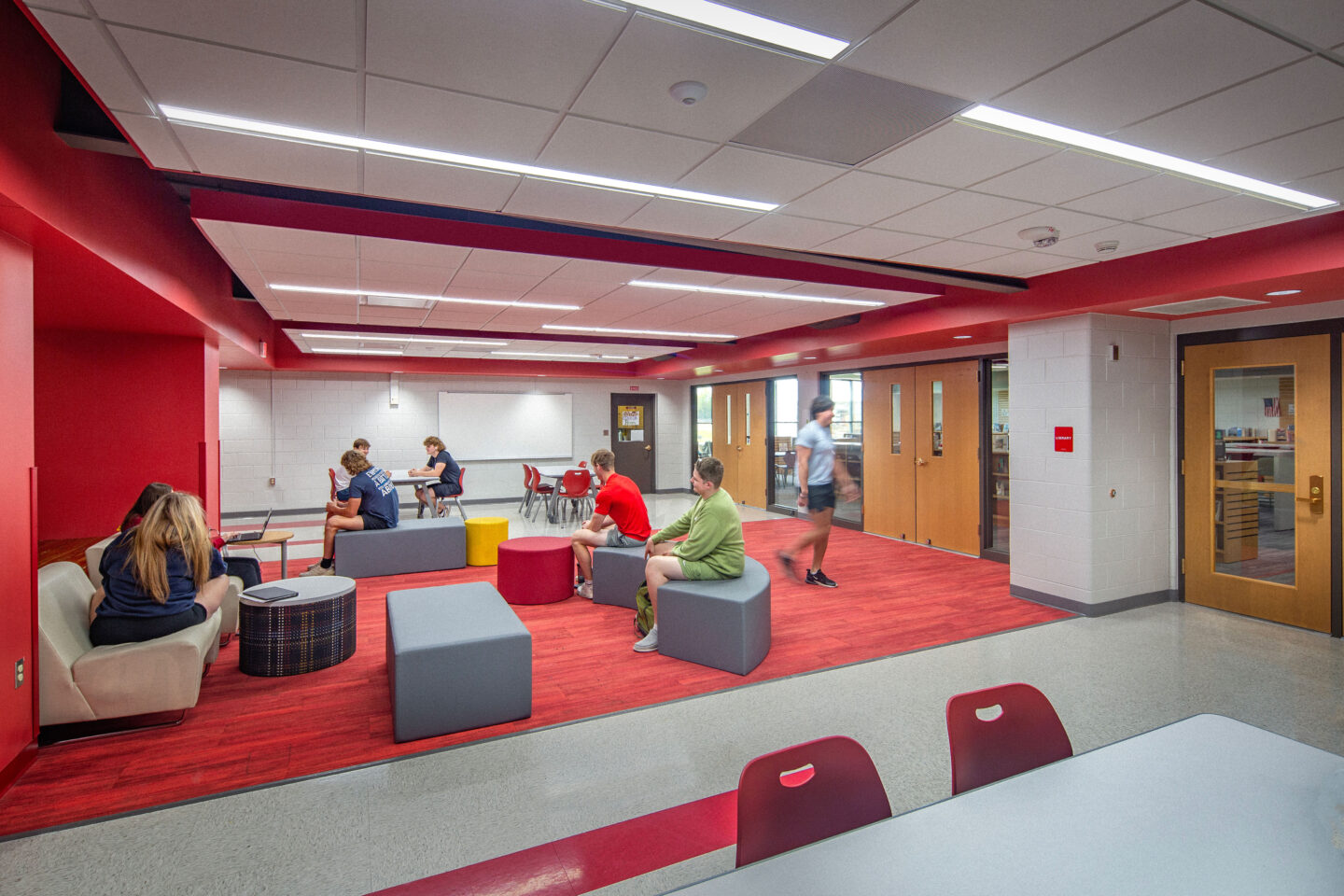 Student collaboration area looking at the library. The collaboration area features furniture to accommodate small groups, including monitors and whiteboards.